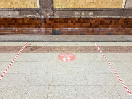 Moscow, Russia - December 10, 2021: Keep the distance. Red warning sticker on the marble floor of Krasnoselskaya metro station. Inscription in Russianのeditorial素材