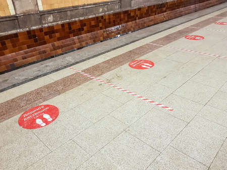 Moscow, Russia - December 10, 2021: Keep the distance. Red warning sticker on the marble floor of Krasnoselskaya metro station. Inscription in Russianのeditorial素材