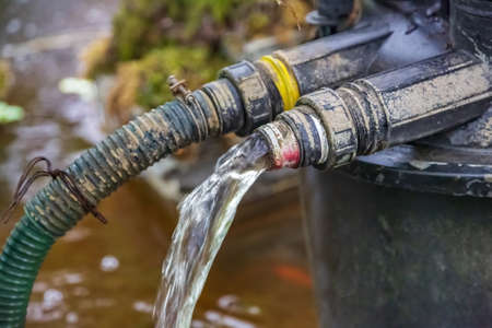 Old metal watering faucet for irrigating plants and flowers in the garden or backyardの写真素材