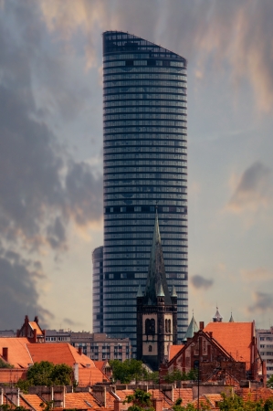 the highest building in wroclaw in combination with the old churchの写真素材