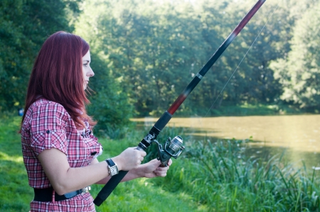 Redhead woman with fishing poleの写真素材
