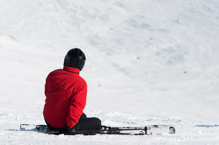 skier sitting on ski slopeの写真素材