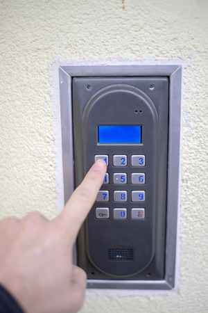Human finger pushing button of house intercomの写真素材