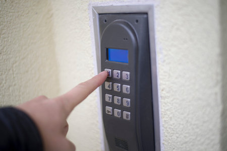 Human finger pushing button of house intercom