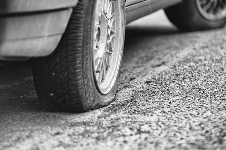 Flat rear tire on a carの写真素材