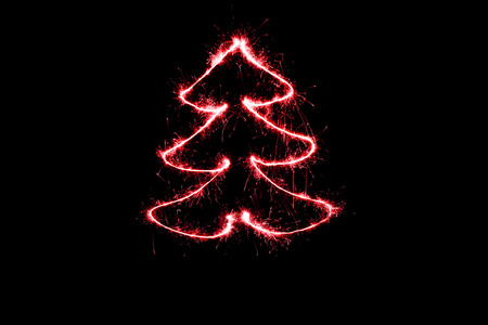 red Christmas tree made by sparkler on a black backgroundの写真素材