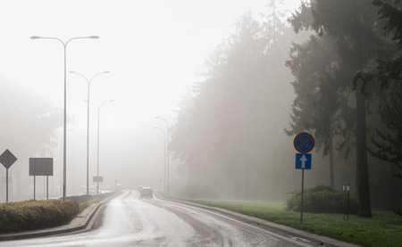 Cars in the fog. Bad weather and dangerous automobile traffic on the road.の写真素材