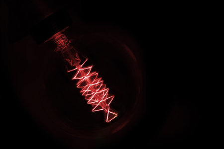 close up on red  light bulb glowing in dark