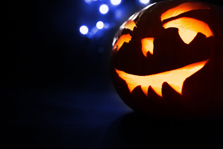 Scary Halloween pumpkins on a blue light background.の写真素材