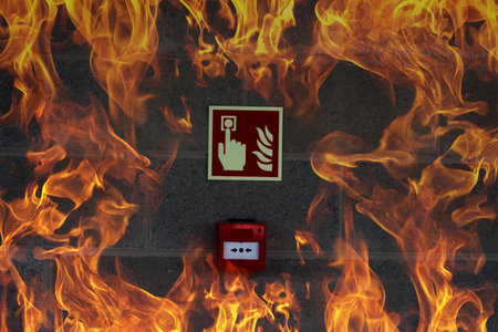 Emergency Fire Exit on the stone wall with fire flamesの写真素材