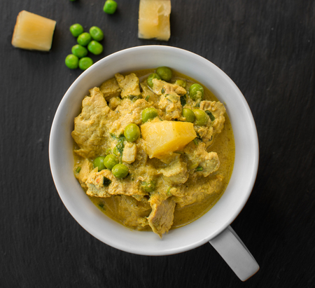 Pineapple, pea and pork stew on black stone backgroundの写真素材