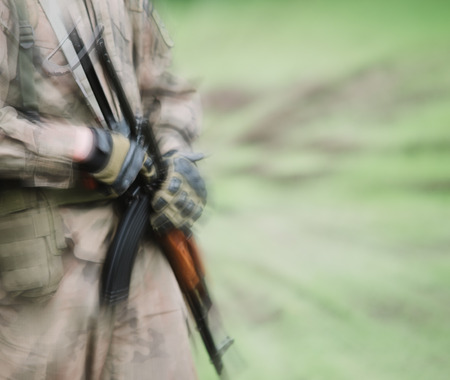 close up on soldier with machine gun, motion blurの写真素材