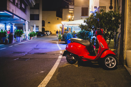 red scooter on an Italian alley with a restaurant in the background, vintage effectのeditorial素材
