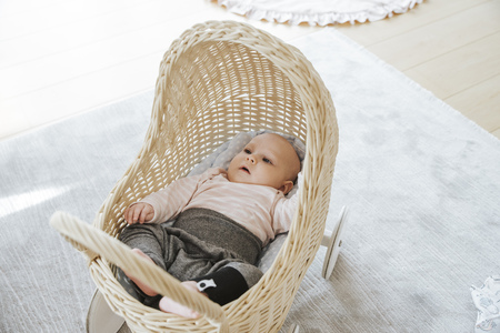 newborn in a toy wicker trolleyの写真素材