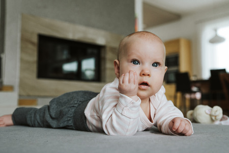 Newborn girl on the floor with Italian gesture handの写真素材