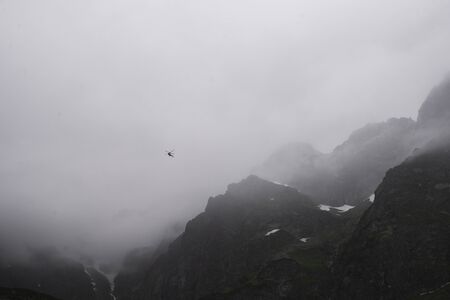 rescue helicopter in the mountains, heavy fog, Tatraの写真素材