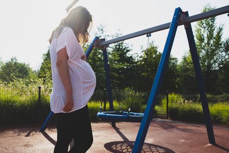 lonely pregnant woman on the playgroundの写真素材