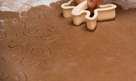 cutting out  a gingerbread with human handの写真素材