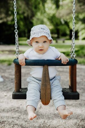 small child is having fun on a swingの写真素材