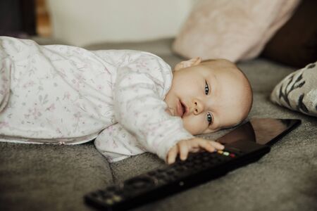 a child with a remote control and a telephone,cの写真素材