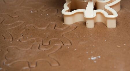 cutting out  a gingerbread with human handの写真素材