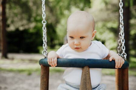 small child is having fun on a swingの写真素材