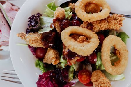 close up on onion rings with saladの写真素材