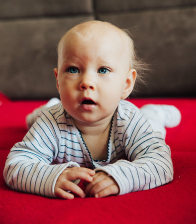 curious baby girl lying on bed
