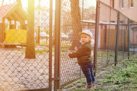 baby girl with blue eyes and blond standing in her bedの写真素材