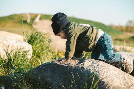 young baby girl climbing on rockの写真素材