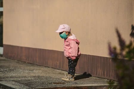 child playing outdoor with covid maskの写真素材