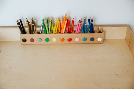 colored pencils in a container on a wooden tableの写真素材