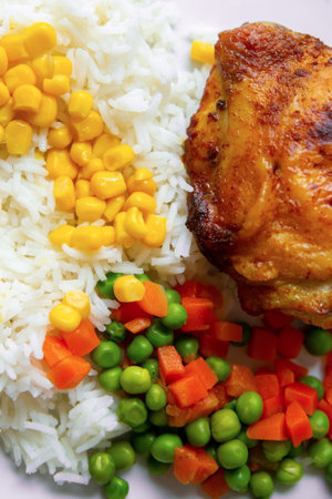 fried chicken leg with rice, corn, carrots and peasの写真素材