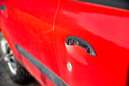 damaged door handle in an old red carの写真素材