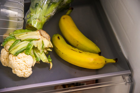 bananas and vegetables in fridge on shelfの写真素材