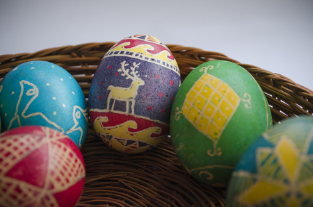 colorful painted Easter eggs in a woven straw basketの写真素材