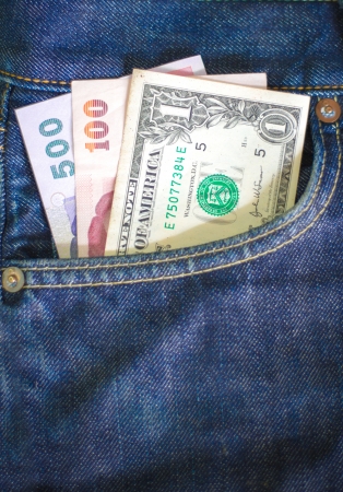 Thai Bath and dollars in a jeans pocket, closeupの写真素材
