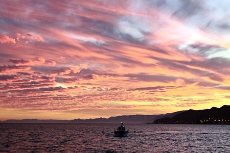 Lonely ship in a sea against the sunset skyの写真素材