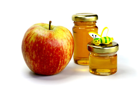 Red apple and two jar of honey on a white backgroundの写真素材