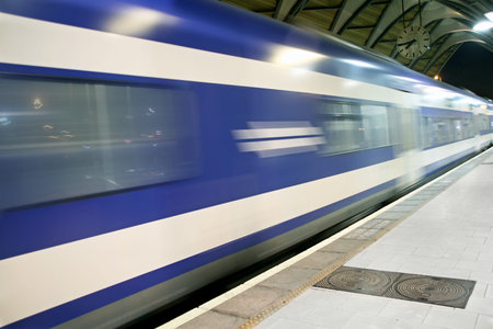 suburban train passes by a passenger platform