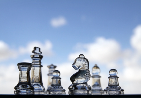 Glass chess pieces on the background of skyの写真素材