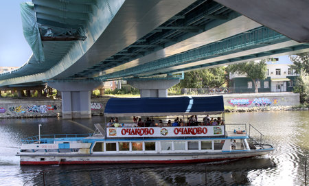 PENZA, RUSSIA - AUGUST 16, 2012: Pleasure boat with passengers sails under the bridge across the river Sura, Penzaのeditorial素材