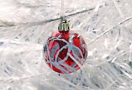 Christmas ball with a pattern on the background of the white artificial firの写真素材