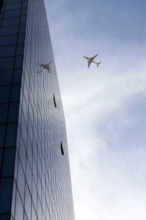 TEL AVIV, ISRAEL - FEBRUAR 12, 2010: Passenger plane flying over the city Tel Aviv near the skyscraperのeditorial素材