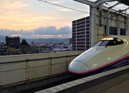 High-speed train is at the platform of the railway station of Fukushima on backgroubd of the sunsetのeditorial素材