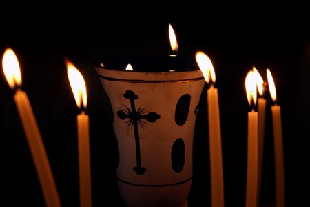 Lampade surrounded by burning candles on a black backgroundの写真素材