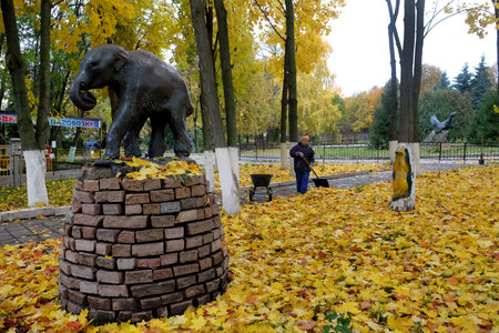 PENZA, RUSSIA - OCTOBER 13, 2017: Attendant collects the fallen leaves in the zooのeditorial素材