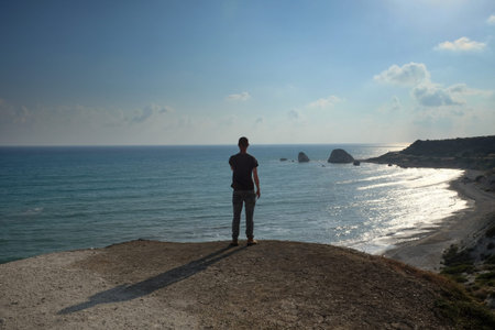 Man stands on the background of the Rock of Aphrodite  in the Mediterranean Sea