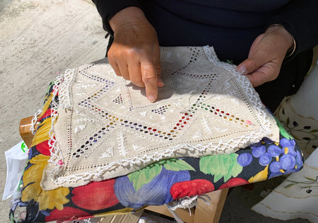 LEFKARA, CYPRUS - MAY 10, 2019:  Craftswoman embroiders a napkin and shows a knot named after Leonardo da Vinciのeditorial素材