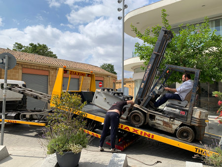 NICOSIA, CYPRUS - MAY 10, 2019:Loading a bank safe onto a trailer using a forkliftのeditorial素材
